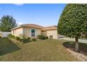 Single-story home with neutral exterior, manicured lawn, and well-placed landscaping at 6610 Crescent Loop, Winter Haven, FL 33884