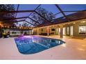 Stunning screened pool at twilight with surrounding patio at 7026 Parliament Pl, Lakeland, FL 33809