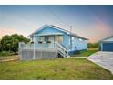 Charming single-story home with blue siding, a front porch, and a well-manicured lawn at 705 Lake Ada Blvd, Dundee, FL 33838