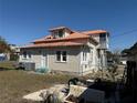 Exterior elevation view of house shows the back entry and partial yard with metal roof and stair case at 118 S 5Th St, Haines City, FL 33844