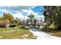 Exterior view of a cozy home featuring a palm tree, a carport, and an American flag at 1290 S Mcadoo Ave, Bartow, FL 33830