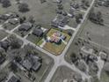 Aerial view of single Gathering house with a brown roof, detached garage and pool with screen enclosure at 1301 Hidden Creek Ct, Winter Haven, FL 33880