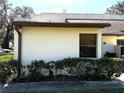 Simple home exterior view featuring tidy shrubs around stucco wall at 1880 N Crystal Lake Dr # 28, Lakeland, FL 33801