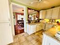 Charming kitchen featuring white cabinetry, granite countertops, and tile flooring at 2015 E Beacon By Way, Lakeland, FL 33803