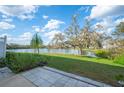 A beautiful lake view sits behind the backyard with patio, grass, and mature trees at 2038 Winterset Dr # 2038, Lakeland, FL 33813