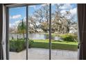 Expansive views of the backyard, lake, and moss-draped tree seen through sliding glass doors at 2038 Winterset Dr # 2038, Lakeland, FL 33813