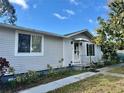 This house has a sidewalk leading up to a covered front entry. It features mature landscaping and a manicured lawn at 209 Ann Ave, Dundee, FL 33838