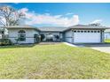 Well-maintained home featuring a manicured front lawn, neutral exterior, and an attached garage at 2532 Everleth Dr, Lakeland, FL 33810