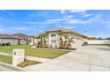 Lovely home with a wide driveway, attached garage, palm trees, and manicured lawn at 2917 Blackwater Creek Dr, Lakeland, FL 33810