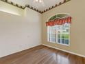 Cozy bedroom featuring wood floors, a large window, and decorative wallpaper at 324 Lake Mariam Blvd, Winter Haven, FL 33884