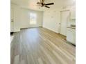 Inviting living room showcasing light gray floors, a ceiling fan, and an exterior door leading to the outside at 3291 Alberta St, Bartow, FL 33830