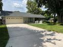 Charming single-story home with a manicured lawn, gray paint, and a two-car garage at 362 Pasco Ct, Winter Haven, FL 33884