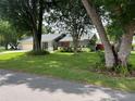 Well-maintained front yard with mature trees and a single-story home in the background at 362 Pasco Ct, Winter Haven, FL 33884