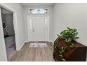 Inviting foyer with wood-look floors, a decorative cabinet, and a view of the front door at 3862 Willow Ridge Dr, Lakeland, FL 33810