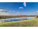 Scenic view of a tranquil pond reflecting the blue sky, surrounded by lush green grass at 4002 Sunset Lake Dr, Lakeland, FL 33810