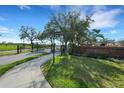 Community entrance featuring secure gate, manicured landscaping, and brick signage for The Enclave at 417 Enclave Pl # 2, Lakeland, FL 33803