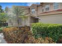 Two story tan home featuring a palm tree and manicured bushes at 417 Enclave Pl # 2, Lakeland, FL 33803