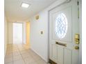 Bright entryway featuring tile flooring, a white door with an oval window, and a hallway leading to other parts of the home at 474 Cameo Dr, Lakeland, FL 33803