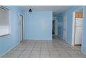 A large, bright living room with neutral tile floors, light blue walls, and multiple doors for easy access at 526 Hampton Ave, Lakeland, FL 33801