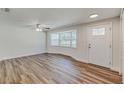 Bright living room features wood floors, a ceiling fan, and a large bay window at 5908 Lunn Rd, Lakeland, FL 33811