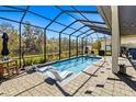 Relaxing screened-in pool area features a covered patio, in-pool seating, and ample space for lounging at 6018 Abbey Oaks Dr, Lakeland, FL 33811