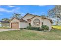 A well-kept house features a two-car garage, a lawn, and a serene view at 6224 Crane Dr, Lakeland, FL 33809