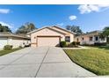 Single-story home with a well-maintained front yard and spacious driveway leading to an attached garage at 6271 Res Cir, Lakeland, FL 33810