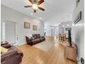 Cozy living room with hardwood floors, ceiling fan, and stylish decor open to dining and kitchen area at 6838 Shimmering Dr, Lakeland, FL 33813