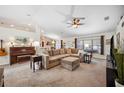 Spacious living room featuring a large sectional couch, carpeted flooring, and a ceiling fan at 6846 Ashbury Dr, Lakeland, FL 33809