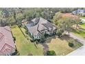 Aerial view of a luxury home with a screened in pool and sprawling backyard surrounded by mature trees at 6942 Indian Creek Park Dr, Lakeland, FL 33813