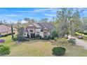 Aerial view of a beautiful home with lush green lawn and mature trees, showcasing its serene setting at 6942 Indian Creek Park Dr, Lakeland, FL 33813