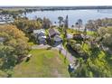 Scenic aerial view of the property showcasing the lush landscaping, lake access, and spacious driveway at 720 Lake Jessie Dr, Winter Haven, FL 33881