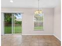 Cozy dining area featuring tile flooring, a sliding glass door to the backyard, and a chandelier at 7444 Hunters Greene Cir, Lakeland, FL 33810