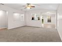 Bright living room featuring neutral paint, plush carpeting, and an open layout to kitchen at 7444 Hunters Greene Cir, Lakeland, FL 33810