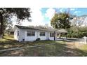 A charming single-story house with a fenced yard and well-maintained lawn at 745 4Th St, Polk City, FL 33868