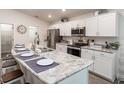 Modern kitchen featuring white cabinets, stainless steel appliances, and a large island with seating at 1108 Mountain Flower Ln, Davenport, FL 33837