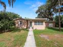 Charming single-story home featuring a quaint front yard, walkway and mature tree coverage at 116 S Lanier Ave, Fort Meade, FL 33841