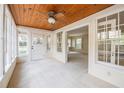 Bright sunroom featuring a wood-paneled ceiling, a ceiling fan, and several windows offering a scenic view of the outdoors at 1819 Pawnee Trl, Lakeland, FL 33803