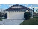 Attached two-car garage with decorative windows and blue trim at 2021 Windward Pass, Lakeland, FL 33813