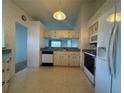 Kitchen with white appliances, cabinets, tile flooring, and wallpaper at 2021 Windward Pass, Lakeland, FL 33813