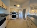 Traditional kitchen with white appliances, cabinets, and view into living room at 2021 Windward Pass, Lakeland, FL 33813