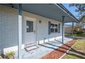 Inviting front porch with white brick and blue accents, leading to a decorative front door at 2926 Delrose N Dr, Lakeland, FL 33805