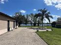 Brick backyard patio with lovely green grass and a scenic view of the lake at 389 Nolane Ln, Polk City, FL 33868