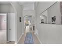 Inviting hallway with neutral walls, tiled floor, arches, decorative mirror, and an open view to the living area at 3978 Viamonte Ln, Lakeland, FL 33810