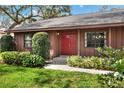 Close up of charming home with a red front door and professional landscaping at 4613 Little Grove Ln, Lakeland, FL 33813