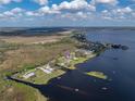 Aerial view of a waterfront property with a metal roof, a detached garage, and its surrounding neighborhood at 5418 Cooper Ln, Fort Meade, FL 33841