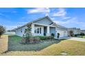 A well-maintained home showcasing its charming exterior with a covered porch and manicured landscaping at 5806 Valentino Way, Lakeland, FL 33812