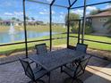 Screened-in patio with comfortable seating area overlooking the lake at 585 Meandering Way, Polk City, FL 33868