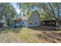 Spacious backyard featuring a covered patio, gravel area and mature trees, ideal for outdoor entertaining at 6615 Broken Arrow S Trl, Lakeland, FL 33813