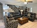 Spacious living room featuring tile floors, black staircase and comfortable seating arrangements at 6615 Broken Arrow S Trl, Lakeland, FL 33813